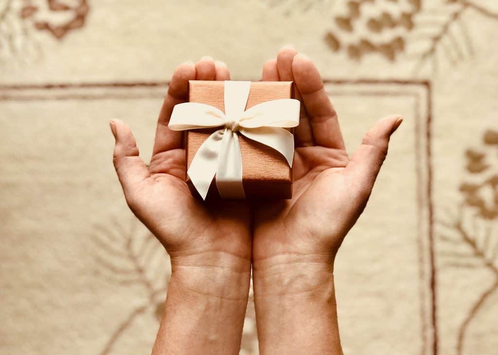 A present in the hands of a person, aligned with Non-Monetary Rewards