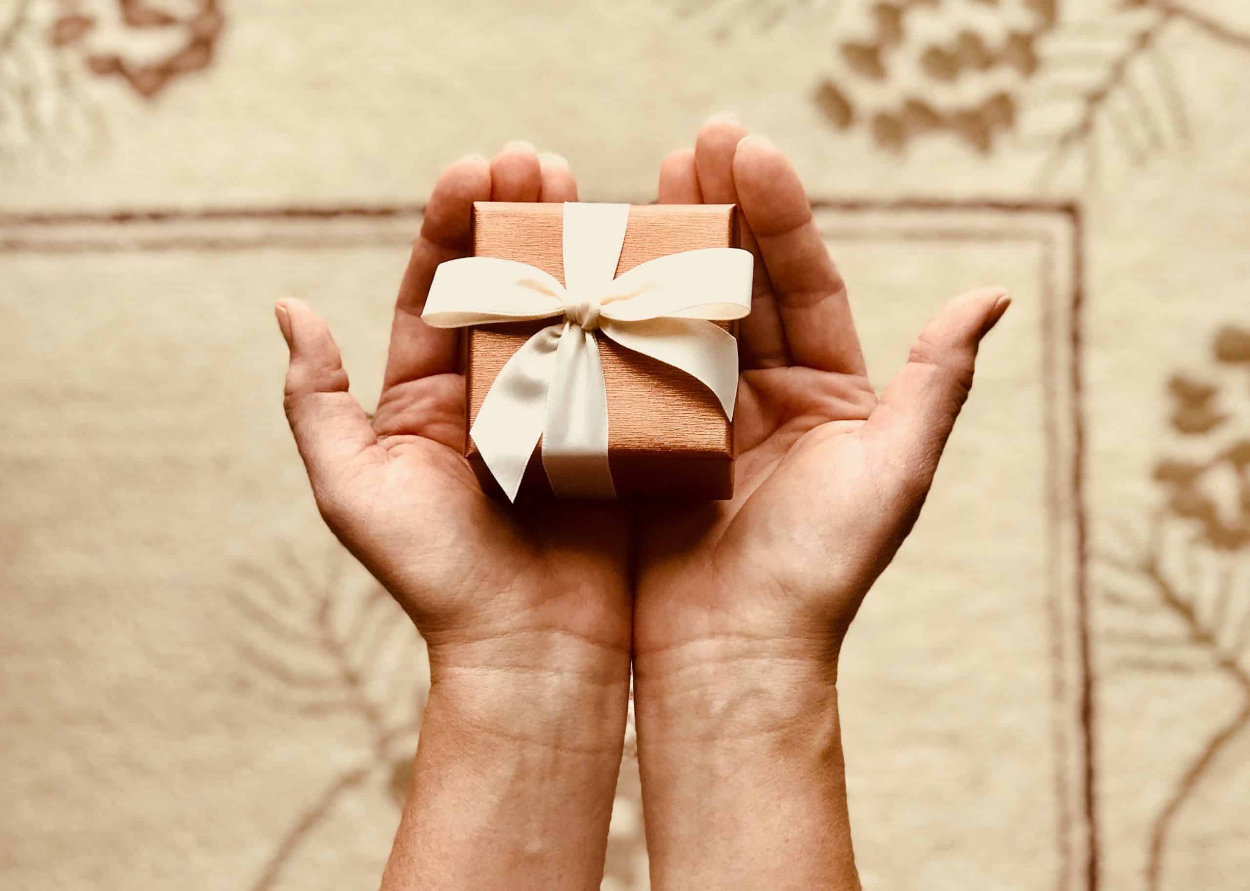 A present in the hands of a person, aligned with Non-Monetary Rewards